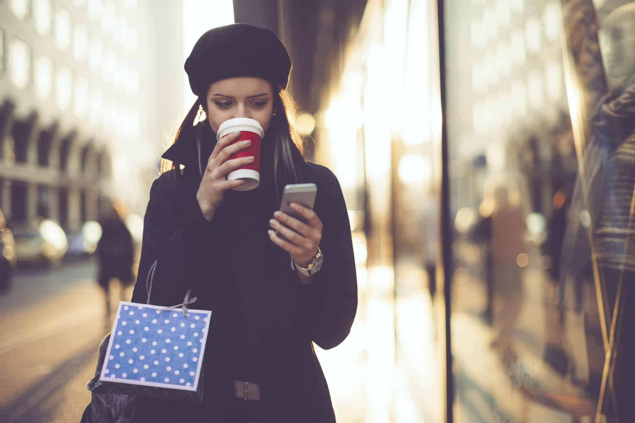 Shopper Sipping Coffee and Holding a Mobile Phone - KX